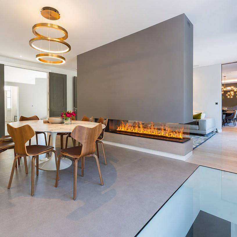 VORAFIRE see-through linear water vapor fireplace in a luxury open-plan dining room